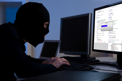 Thief wearing mask on a computer